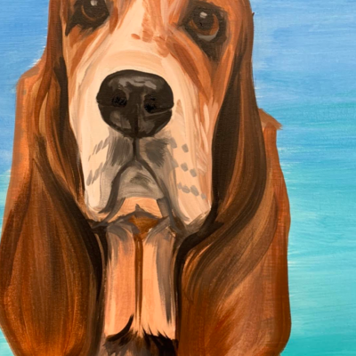 a brown dog standing next to a body of water